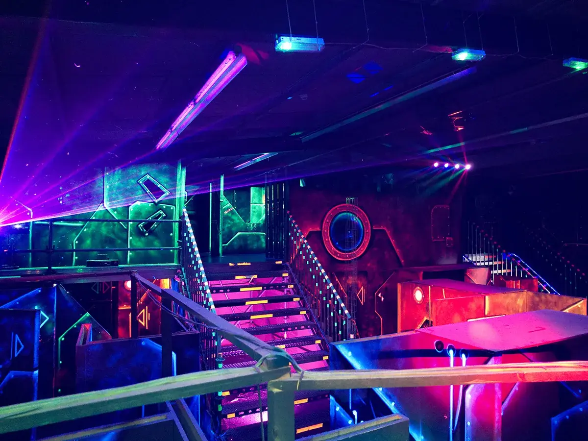 Futuristische Halle mit bunten Lichtern und Lasern. Ein aufregender Ort für Schwarzlicht Minigolf in Heidelberg.