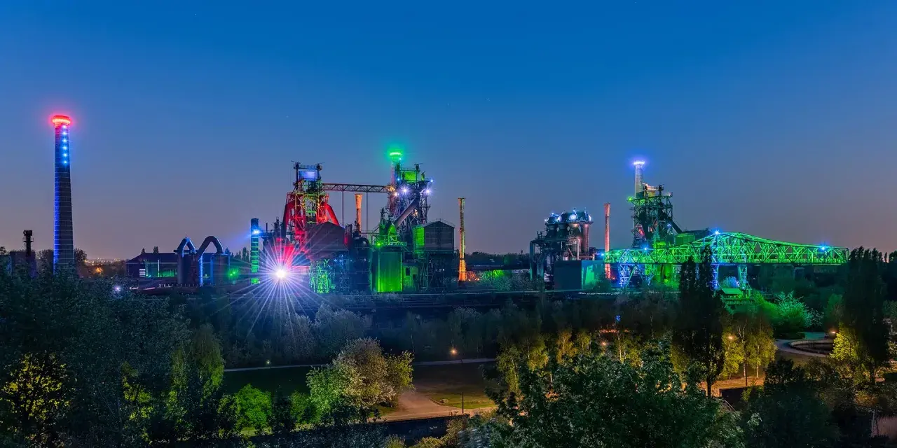 Industriepark Landschaftspark Nord in Duisburg bei Nacht, beleuchtet in bunten Farben. Ein toller Ort, um zu sehen, was man in Duisburg machen kann!