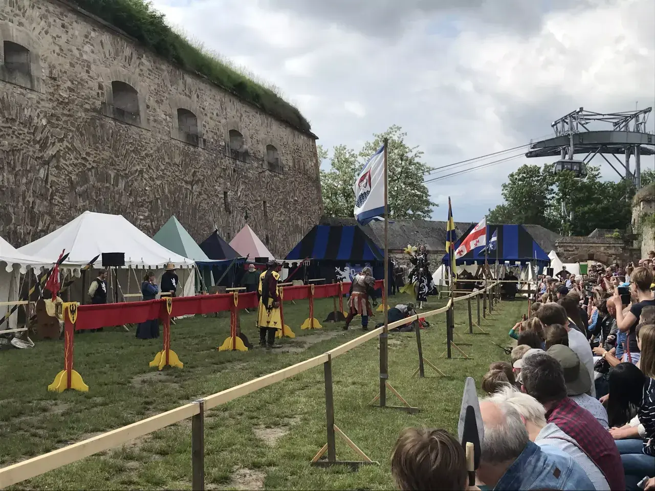 Ritterkämpfe vor der Festung Ehrenbreitstein. Ein mittelalterliches Spektakel mit Zelten und Zuschauern, das an einen historischen Spielplatz erinnert.