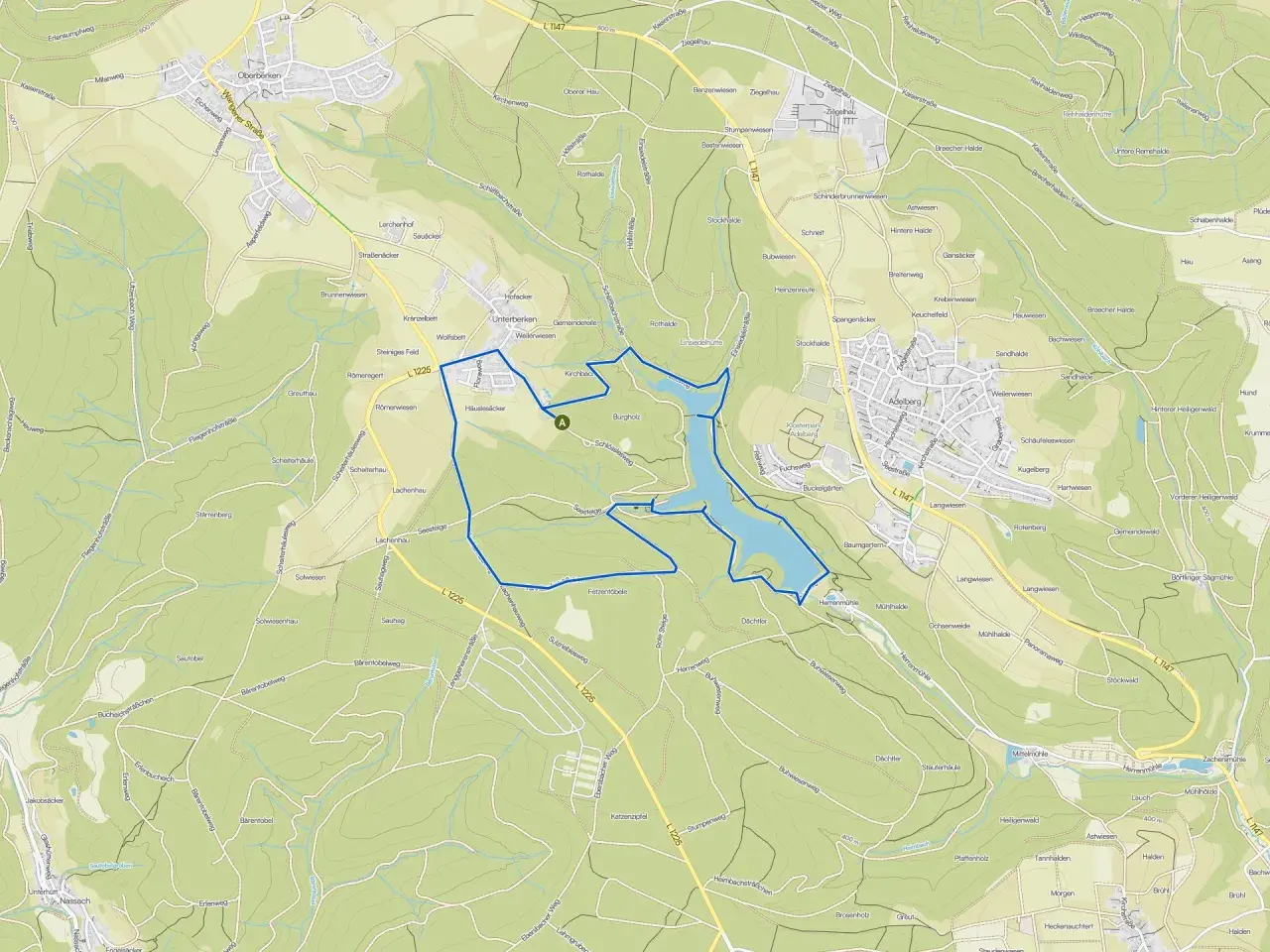 Der Herrenbachstausee mit seiner Kugelbahn-ähnlichen Uferlinie, eingebettet in grüne Hügel und Wälder.