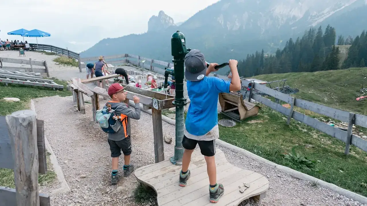 Kinder spielen am Juwelenweg Pfronten mit Bergpanorama.
