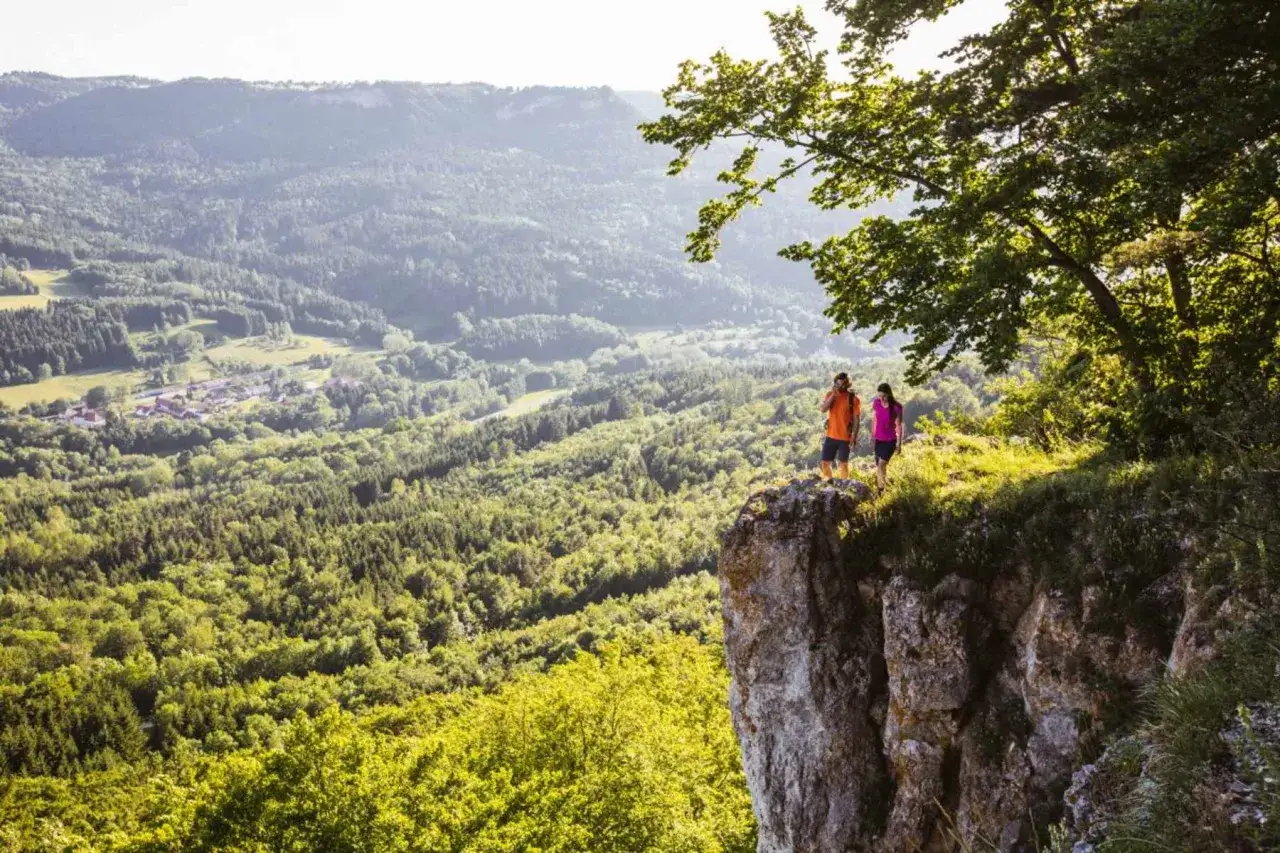 Zwei Wanderer auf einem Felsvorsprung genie&szlig;en den Blick &uuml;ber das Felsenmeer Albstadt.