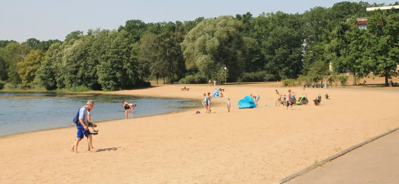 Sommerliche Strandatmosphäre am Badesee. Hier kann man entspannen und baden – eine schöne Möglichkeit, was man in Wolfsburg machen kann.