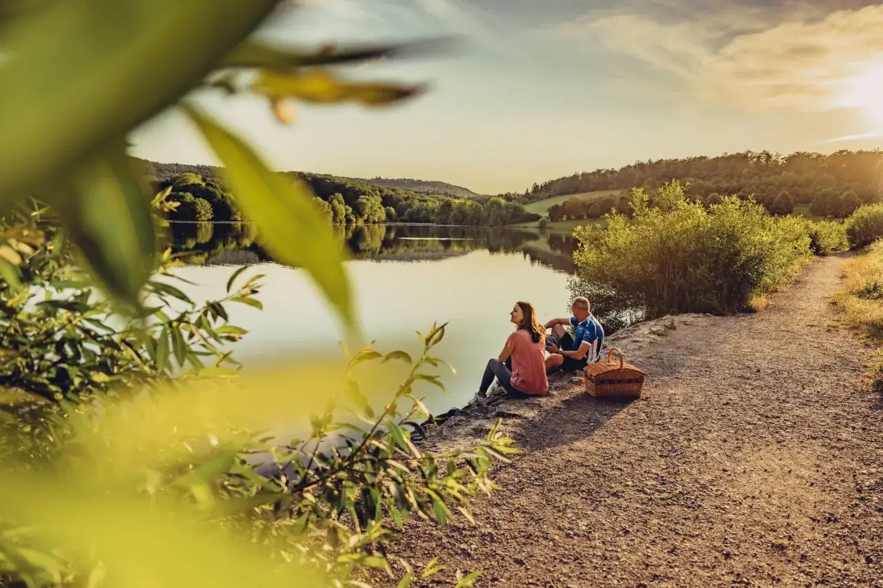 Ein Paar genießt den Sonnenuntergang am badesee Zaberfeld. Ein Picknickkorb steht bereit.