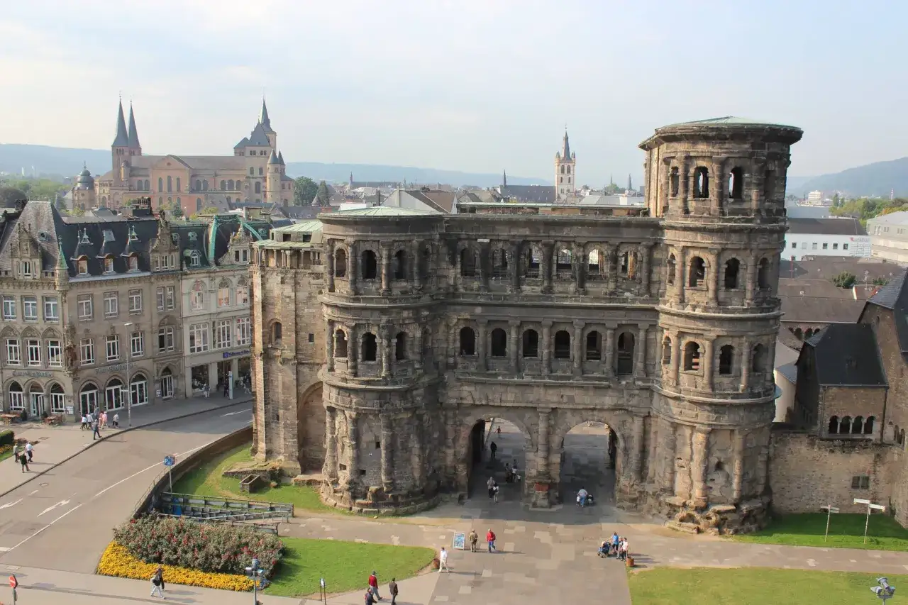 Porta Nigra in Trier mit Kindern, die davor spazieren. Die beeindruckende römische Stadttor-Ruine ist ein beliebtes Ausflugsziel.