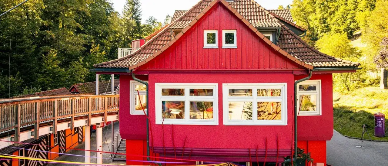 Ein leuchtend rotes Haus mit Holzbr&uuml;cke und bunten B&auml;ndern. Hier gibt es Spa&szlig; f&uuml;r eins und alles ab welchem Alter auch immer.