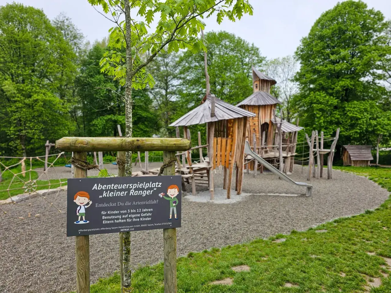Holzspielturm mit Rutsche und Kletterelementen. Der Abenteuerspielplatz „kleiner Ranger“ im Affenberg Salem lädt zum Entdecken ein.