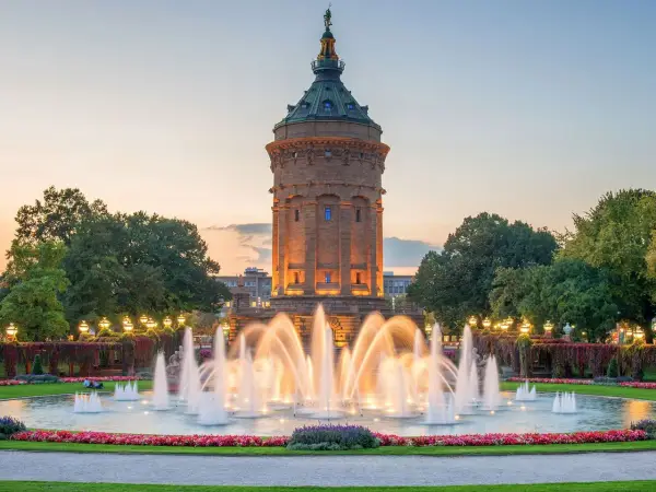 Wasserturm Mannheim mit beleuchtetem Springbrunnen im Abendlicht. Ein schöner Ort, um zu entspannen und zu sehen, was man in Mannheim machen kann.